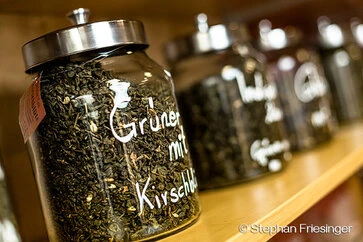 Mit Tee gefüllte Gläser im Regal