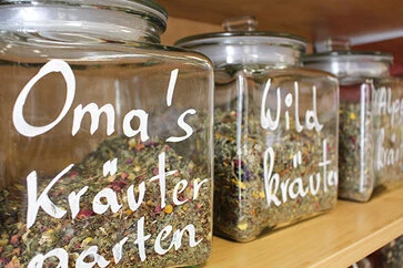 Mit Tee gefüllte Gläser im Regal